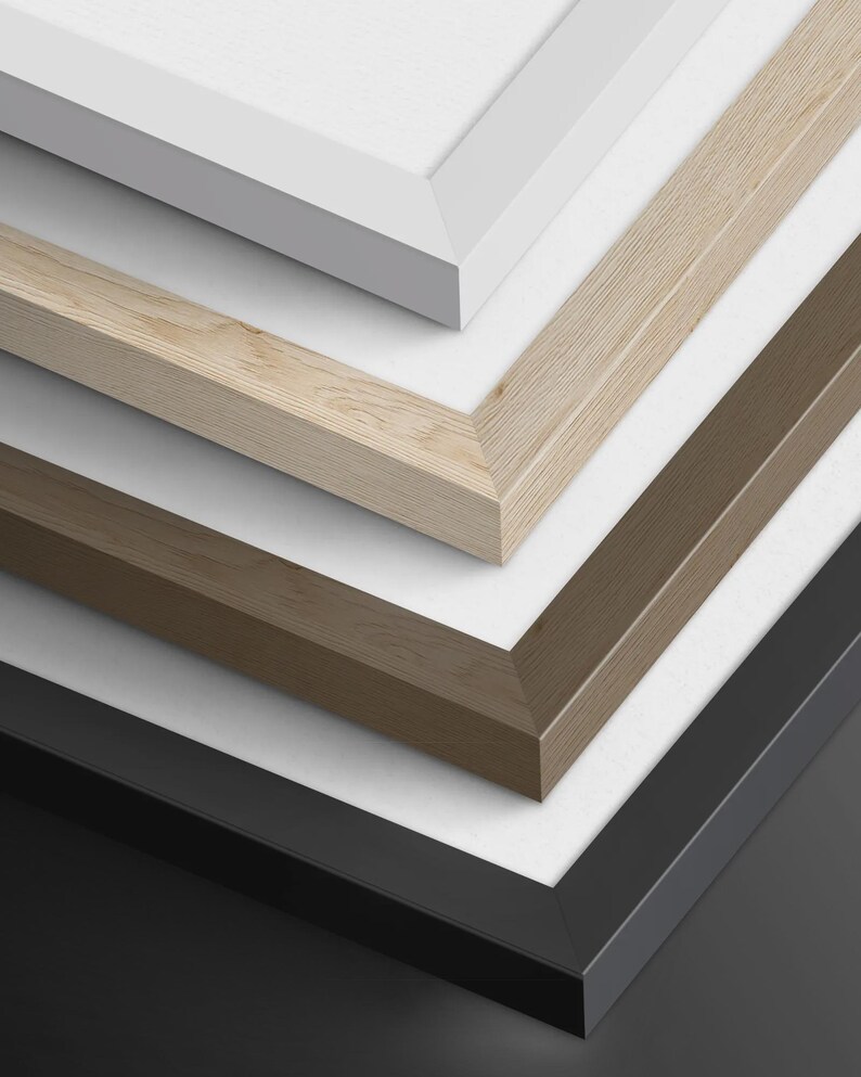 May include: A stack of four rectangular picture frames with mitered corners. The frames are arranged in a descending order, featuring a smooth white finish, a light natural wood grain, a medium brown wood grain, and a solid matte black finish.