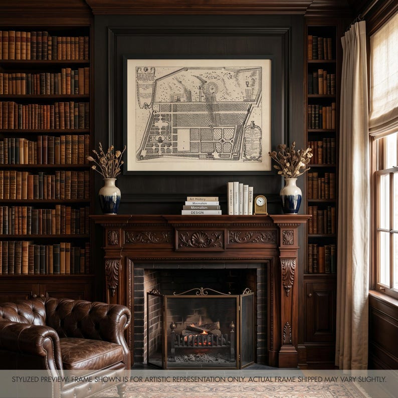 May include: A framed black and white architectural garden map print hanging above a dark wood fireplace mantel. The mantel features two white and blue vases with dried botanicals, a stack of books, and a small gold clock on a dark wall.