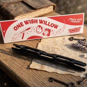 May include: A rectangular white box with red accents featuring the text ONE WISH WILLOW, AMAZE YOUR FRIENDS!, and You only, get ONE WISH, alongside a black, elongated, hollow, cage-like object with a textured surface and multiple openings.