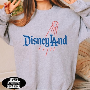 A person wearing a gray sweatshirt with the text "Disneyland" printed on it.
