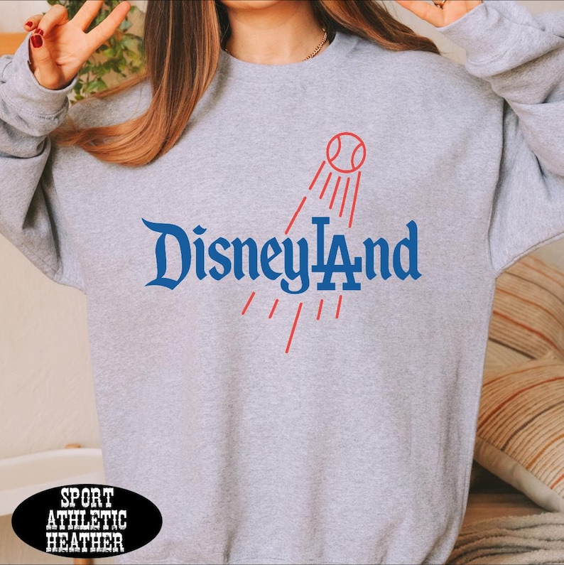 A person wearing a gray sweatshirt with the text "Disneyland" printed on it.