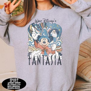 A gray sweatshirt with a graphic design featuring a character from the Disney movie "Fantasia".