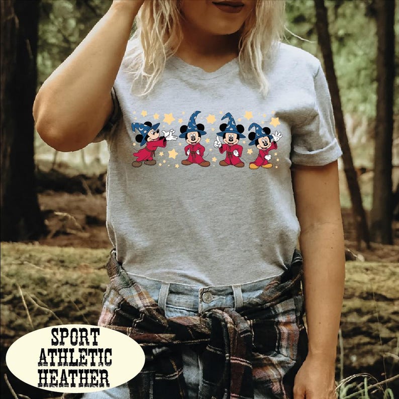 A woman wearing a gray t-shirt with a graphic of Mickey Mouse and a text overlay that says "Sport Athletic Heather".