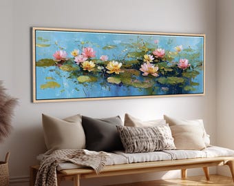 May include: A rectangular framed painting depicts a serene water scene with pink and yellow lotus flowers and lily pads. The artwork is set against a light blue background, creating a tranquil atmosphere. The painting is displayed above a wooden bench with pillows and a blanket.
