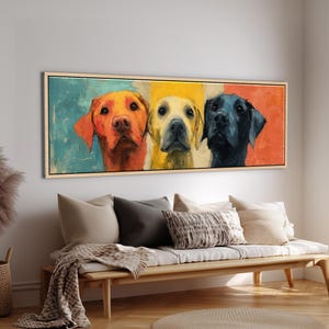 Peut inclure: Impression sur toile encadrée représentant trois labradors. Les chiens sont peints dans un style pop art avec des couleurs vives : orange, jaune et noir. L'œuvre est exposée au-dessus d'un banc en bois.