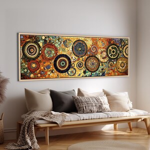 Puede incluir: Una pieza de arte mural rectangular que presenta un diseño de mosaico con numerosos círculos concéntricos y patrones en espiral en tonos naranja, dorado, azul y negro, enmarcada en madera clara y montada horizontalmente en una pared blanca.