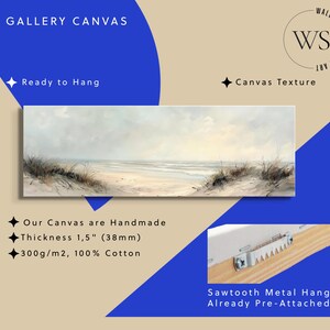 May include: A rectangular gallery canvas featuring a coastal landscape painting with a sandy beach, dunes, and a calm sea under a soft sky. The canvas has a 1.5 inch thickness and includes a pre-attached sawtooth metal hanger on the wooden frame.