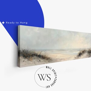 May include: A panoramic canvas print featuring a coastal landscape with sandy dunes, tall beach grass, and a calm ocean under a soft, overcast sky. The artwork displays muted beige, gray, and white tones. Text on the image reads Ready to Hang.