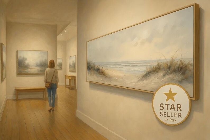 May include: A large horizontal framed canvas painting depicting a coastal beach scene with sand dunes and ocean waves, displayed on a wall. A circular badge with a gold star and the text STAR SELLER on Etsy is positioned in the lower right corner.