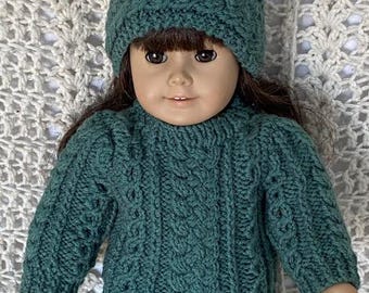 May include: A green knitted sweater with a cable knit pattern, worn by a doll with brown hair and a green headband.