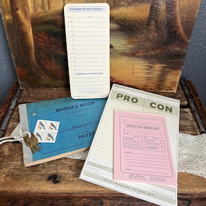 May include: A set of three vintage office supplies: a to-do list notepad, a pink "While You Were Out" message pad, and a blue invoice book. The to-do list notepad has a white background with blue lines and the text "Things to Do Today". The message pad has a pink background with white text and the words "Pro" and "Con" printed on the top. The invoice book has a blue cover with the text "Invoice Book" and "Triplicate" printed on the front.