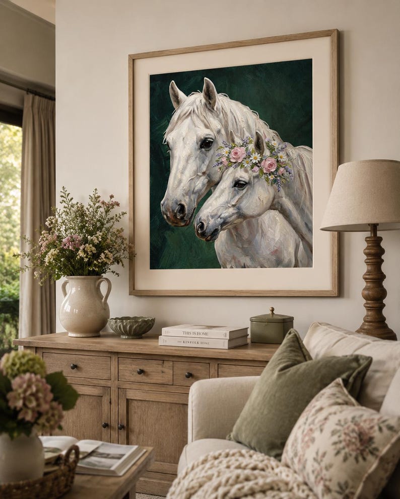 Op de afbeelding: Een ingelijste print met twee witte paarden, waarvan &eacute;&eacute;n met een bloemenkrans, tegen een donkergroene achtergrond. De lijst is lichtbruin. Het kunstwerk wordt in een woonkamer getoond.