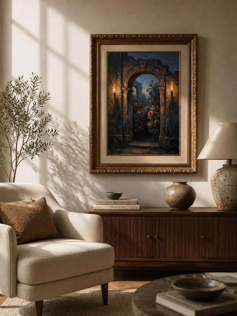 May include: An ornate gold-framed painting of a floral scene within an archway, lit by sconces. The room includes a beige armchair, a wooden cabinet, and a table lamp, creating a warm atmosphere. The painting's style suggests a classic, elegant interior design.