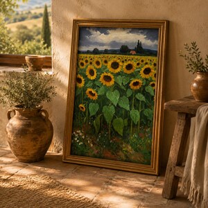 May include: A framed painting of a sunflower field with a gold-colored frame. The sunflowers are yellow with green leaves, set against a backdrop of a cloudy sky and a distant red-roofed building. The painting is leaning against a wall.