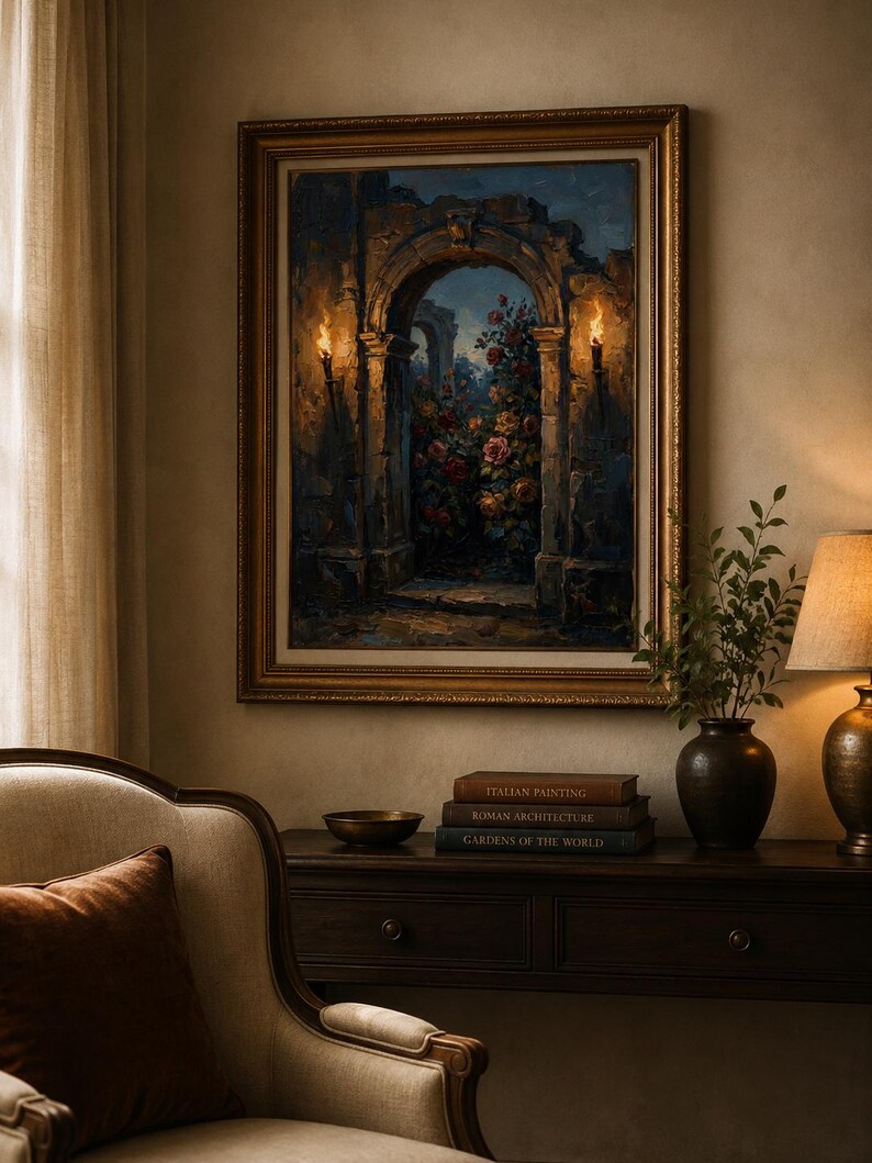 May include: A framed painting shows an archway with torches, leading to a rose garden. The painting is in a gold frame, displayed above a dark wood console table. Books and a bronze bowl are on the table.