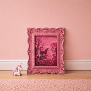 May include: A pink framed painting of a unicorn in a forest scene, with a matching unicorn figurine. The painting and frame are in shades of pink and red, set against a pink wall and a wooden floor.