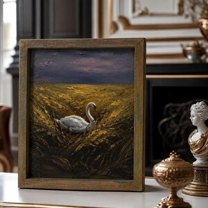 May include: An oil painting in a wooden frame shows a white swan in golden reeds beneath a dusky sky. The frame has a distressed, antique finish. The artwork is displayed on a white surface. The painting evokes a sense of serenity and natural beauty.