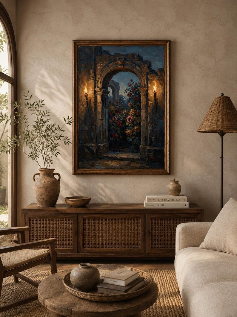 May include: An oil painting in a wooden frame shows an archway with flowers and torches. The painting hangs above a wooden cabinet with woven doors. A vase with greenery, a lamp, and a sofa are also visible.