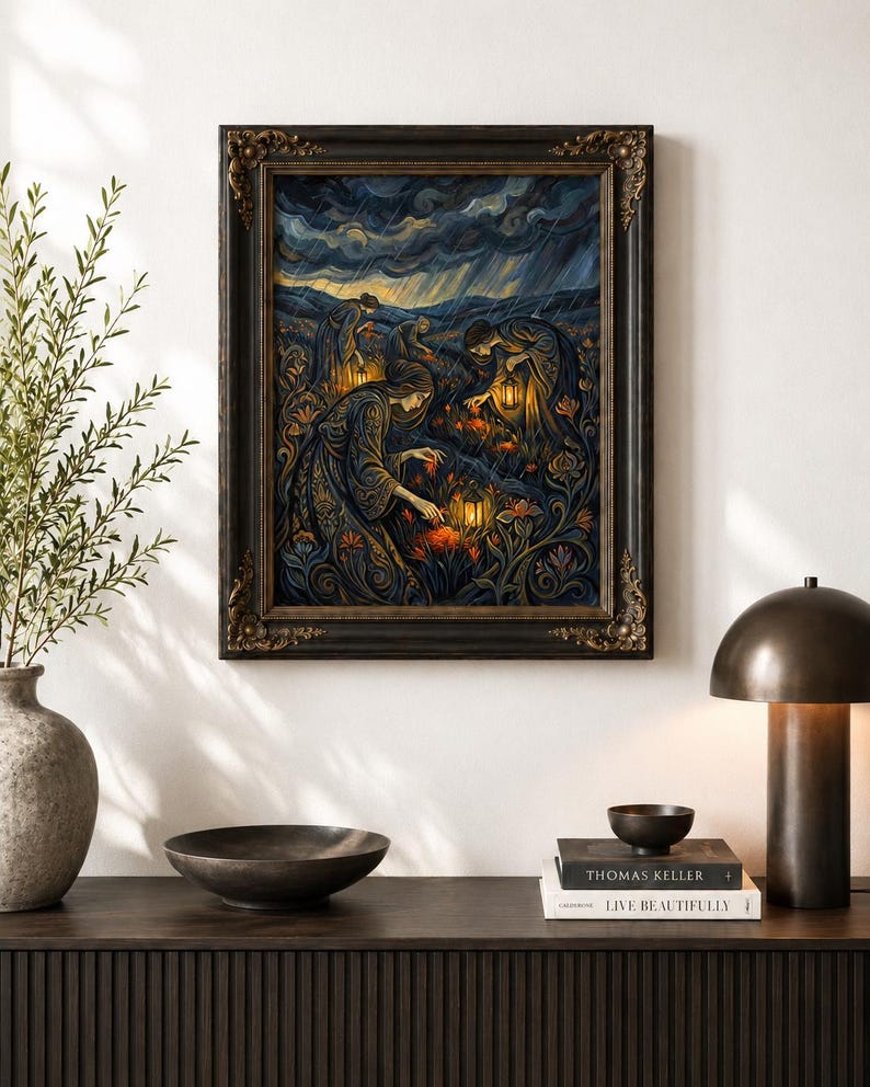 May include: A framed artwork depicts figures with lanterns in a field under a stormy sky. The painting features a dark color palette with ornate details, set within a decorative, dark-toned frame. The artwork is displayed on a dark wooden surface.