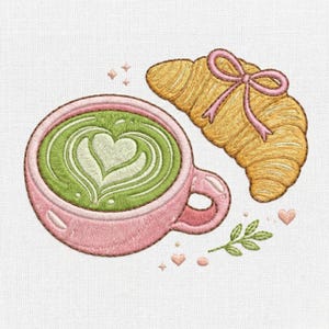 Puede incluir: Diseño bordado con una taza rosa llena de arte latte matcha, un cruasán dorado con un lazo rosa y elementos decorativos. El arte latte tiene forma de corazón. El diseño está sobre un fondo blanco.