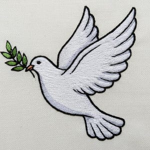 Puede incluir: Paloma blanca bordada con una rama de olivo verde en el pico. La paloma está representada en vuelo, con detalles de costura en las alas y las plumas. El diseño está delineado con hilo negro, sobre un fondo de tela neutra.