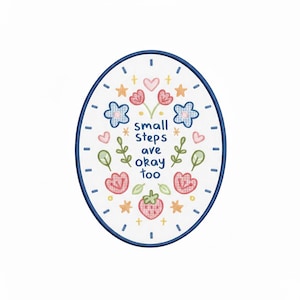 May include: An oval-shaped embroidered patch with a blue border. The design features flowers, stars, hearts, and the text "small steps are okay too." The color palette includes pink, blue, green, and yellow on a white background.