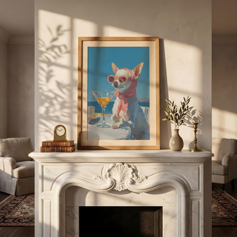 Puede incluir: Una impresi&oacute;n art&iacute;stica enmarcada representa un chihuahua con gafas de sol y una bufanda rosa, disfrutando de un c&oacute;ctel. El perro est&aacute; sentado en una mesa con una copa de martini, sobre un fondo de cielo azul y oc&eacute;ano. La obra de arte est&aacute; en un marco de madera.
