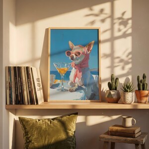 Puede incluir: Una impresi&oacute;n art&iacute;stica enmarcada representa a un chihuahua con gafas de sol rosas y una bufanda, disfrutando de un c&oacute;ctel. El perro est&aacute; sentado en una mesa con un fondo de oc&eacute;ano azul. La impresi&oacute;n se exhibe en un estante con discos de vinilo y cactus en macetas.