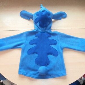 May include: A white ceramic mug with a black handle and the text "But first, coffee" in a black, handwritten-style font. The mug is on a white surface.