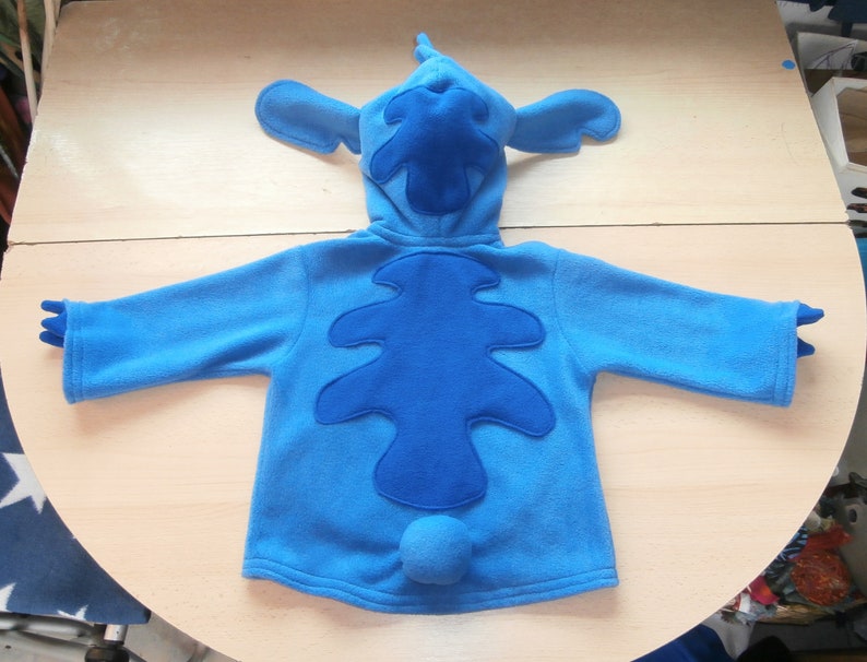 May include: A white ceramic mug with a black handle and the text "But first, coffee" in a black, handwritten-style font. The mug is on a white surface.