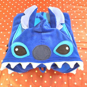 May include: A white ceramic mug with a black handle and the text "But First, Coffee" in a bold, black font. The mug is on a white surface. The mug is approximately 10 cm tall.