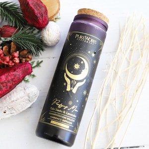 May include: A black glass bottle with a gold label and a cork top. The label features a crescent moon, stars, and the text "Resting Moon Palo Santo & Lavender Manifestation Willow Ambiance Diffuser".