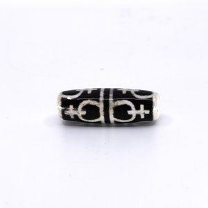 May include: Black and white agate bead with a repeating pattern of symbols.