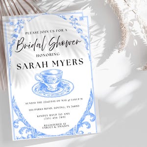 May include: Bridal shower invitation with a blue and white floral design. The invitation includes the text "Please join us for a Bridal Shower honoring Sarah Myers." The invitation also includes the date, time, and location of the event.