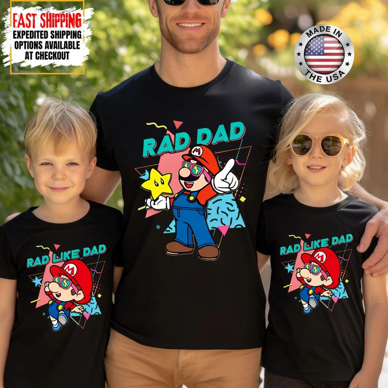May include: Black t-shirts with a graphic of a cartoon character wearing sunglasses and a red hat. The shirts read "RAD DAD" and "RAD LIKE DAD" in a retro font. The shirts are worn by a father and two children.
