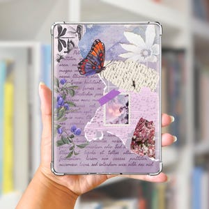 May include: A clear case for an e-reader featuring a collage design. The design includes a butterfly, floral elements, and handwritten text in shades of purple, blue, and white. The case is held in a person's hand.