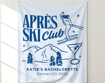 May include: White wall hanging with blue text and illustrations. The words "APRES SKI Club" are at the top, with a skier, mountains, trees, and a martini glass. The text "KATIE'S BACHELORETTE Denver, CO 2026" is at the bottom.