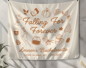 May include: Cream-colored tapestry with brown illustrations and text. The words "Falling For Forever" are in the center, with "Lauren's Bachelorette" below. The tapestry includes drawings of fall-themed items like pumpkins and leaves.