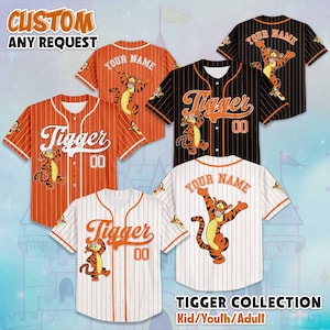 May include: Baseball jerseys in orange, black, and white, featuring the character Tigger. The jerseys have the word "Tigger" and the number "00" on the front. Some jerseys have "YOUR NAME" on the back. The image also includes the text "CUSTOM ANY REQUEST" and "TIGGER COLLECTION Kid/Youth/Adult".