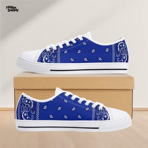 May include: Blue bandana print canvas sneakers with white laces and soles. The low-top shoes feature a classic design with a blue paisley pattern on the canvas upper, perfect for casual wear.