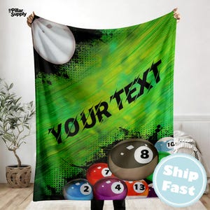 May include: A green and black blanket featuring a large white baseball and the text "YOUR TEXT". The blanket has a design of billiard balls, including the number 8 ball. The blanket is held up by a person.