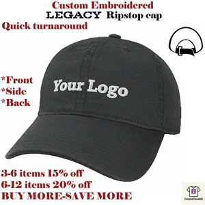 Peut inclure: Casquette Legacy Ripstop noire avec le texte "Your Logo" brodé. La casquette a une visière incurvée et un bouton sur le dessus. Le texte sur l'image indique "Custom Embroidered LEGACY Ripstop cap" et "Quick turnaround."