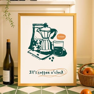 Op de afbeelding: Een ingelijste print met een gouden rand met een turquoise illustratie van een koffiezetapparaat, koffiebonen en een glas koffie. De tekst "It's coffee o'clock" staat eronder. Een fles en een mand met appels staan op de voorgrond.