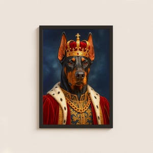 May include: A framed portrait of a Doberman Pinscher wearing a gold crown, a red velvet robe, and a gold chain. The dog has a black and brown coat and is set against a dark blue background.