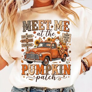 Puede incluir: Una camiseta color crema con un gráfico de un camión vintage naranja rodeado de elementos otoñales como calabazas, girasoles y un fantasma. El texto dice MEET ME at the PUMPKIN patch, con letreros de HAY RIDES, APPLE CIDER y FARM FRESH FUN.