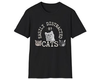 May include: Black t-shirt with the text "EASILY DISTRACTED BY CATS" in a circular design. The design includes three cat faces. The shirt is made of a soft material and has short sleeves.