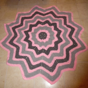 May include: A pink and gray crocheted star-shaped rug with a multi-layered design.