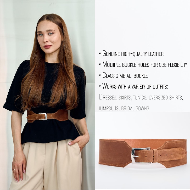 May include: A wide, brown leather belt with a silver-colored metal buckle. The belt is shown on a person wearing a black top and tan pants. The belt has multiple buckle holes for size flexibility.