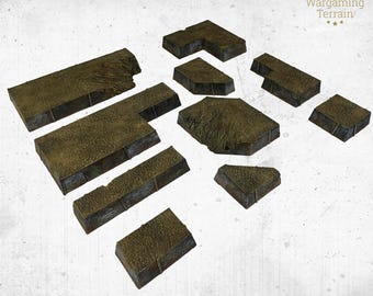 Pode incluir: Uma coleção de peças de terreno castanhas e bege para wargames de mesa. As peças variam em forma e tamanho, incluindo formas retangulares, em forma de L e irregulares. As superfícies têm uma aparência texturizada e desgastada, sugerindo um cenário de campo de batalha. O logotipo HRC Wargaming Terrain é visível.