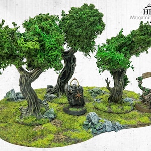 May include: A miniature wargaming terrain piece with three trees, green foliage, and textured brown trunks. The base is covered in green moss and small rocks. Two miniature figures are present, one with a shield and the other an orc with a weapon. The logo "HRC Wargaming Terrain" is visible.